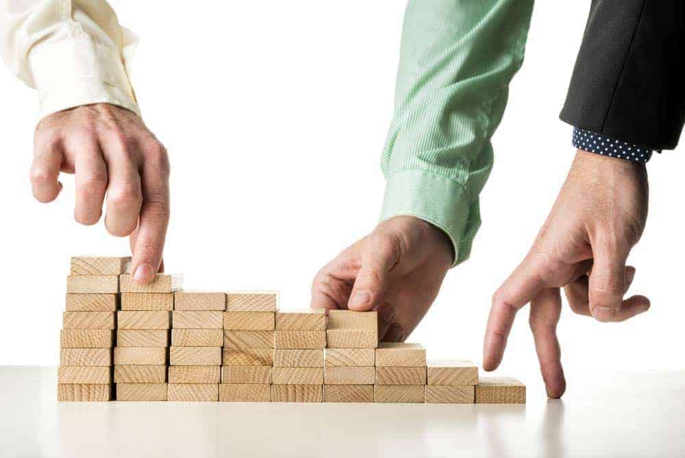 Treppe aus Holzbausteinen mit Händen